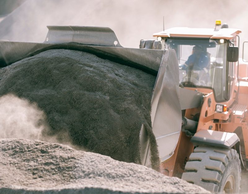 Man driving a bulldozer in a coal quarry, and is exposed to dust diseases but protected by workers compensation