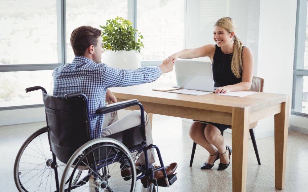 Man with TPD and woman shaking hands because of agreed upon employment After Disability benefits