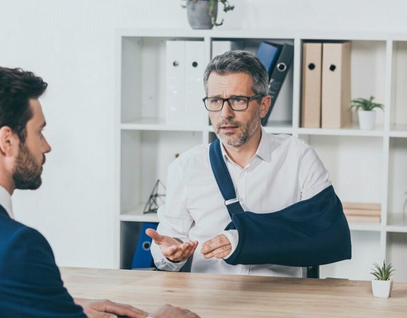 Injured man asking for help from a motor vehicle accident lawyer at the office