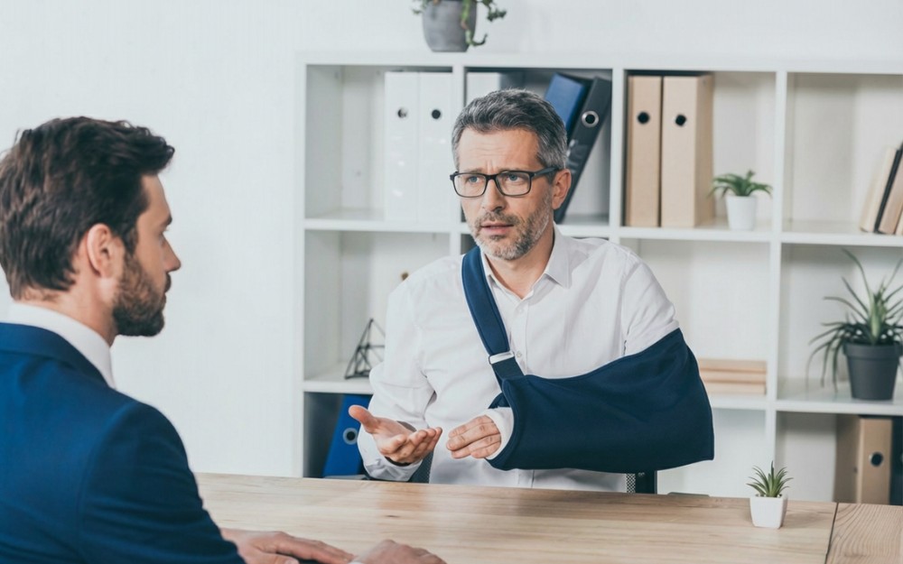 Injured man asking for help from a motor vehicle accident lawyer at the office